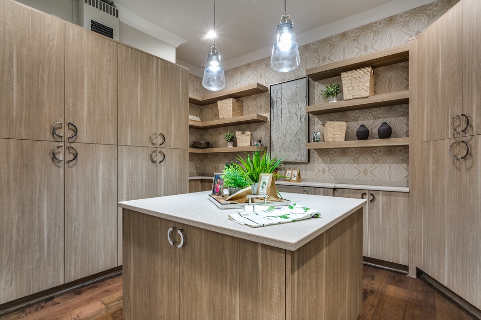 Photo of a transitional u-shaped kitchen pantry in Other with flat-panel cabinets, light wood cabinets, beige splashback, panelled appliances, dark hardwood floors, with island, brown floor and grey benchtop.