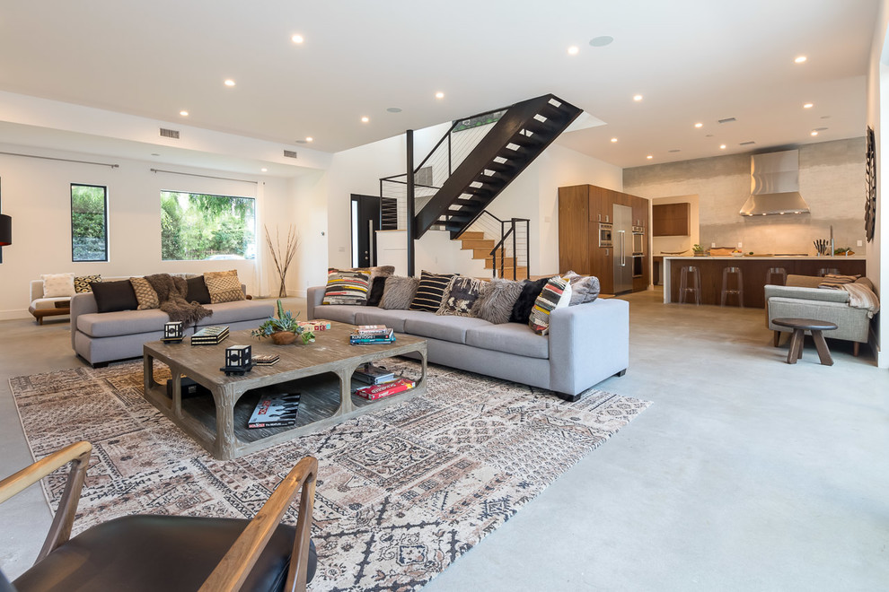 Photo of a large modern open concept living room in Los Angeles with white walls, concrete floors and grey floor.