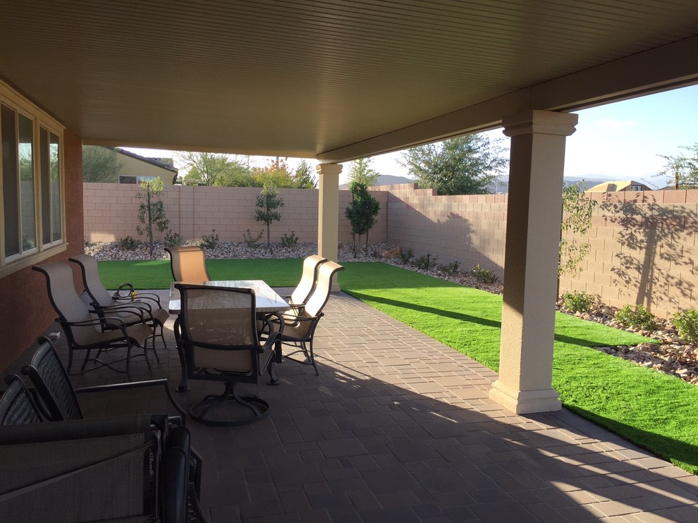 Photo of a mid-sized traditional backyard patio in Las Vegas with brick pavers and a roof extension.