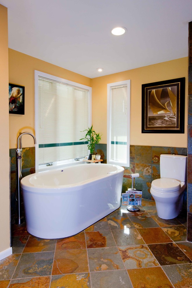 Freestanding bathtub - mid-sized transitional master multicolored tile and stone tile slate floor freestanding bathtub idea in Seattle with an undermount sink, shaker cabinets, medium tone wood cabinets, granite countertops, a two-piece toilet and yellow walls