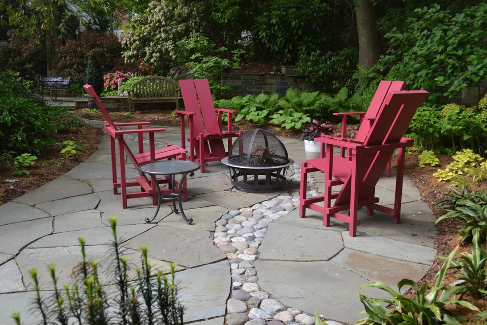 This is an example of a mid-sized eclectic backyard patio in DC Metro with a fire feature and natural stone pavers.
