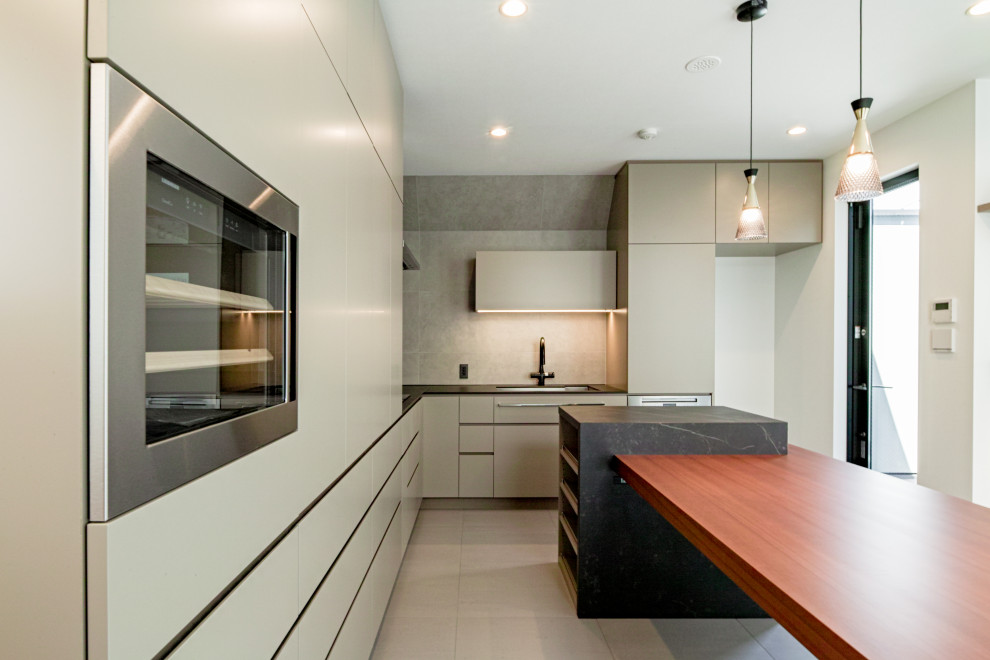 Design ideas for a modern l-shaped open plan kitchen in Tokyo with flat-panel cabinets, grey cabinets, ceramic splashback and with island.