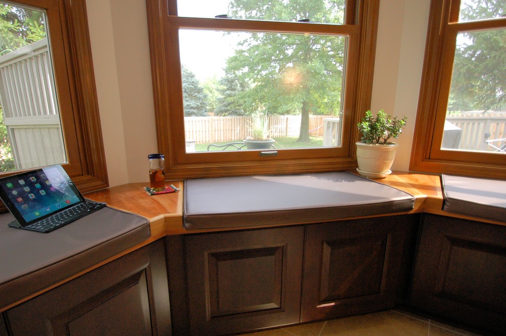 Inspiration for a large transitional l-shaped eat-in kitchen remodel in Columbus with an undermount sink, raised-panel cabinets, dark wood cabinets, granite countertops, gray backsplash, ceramic backsplash, stainless steel appliances and an island