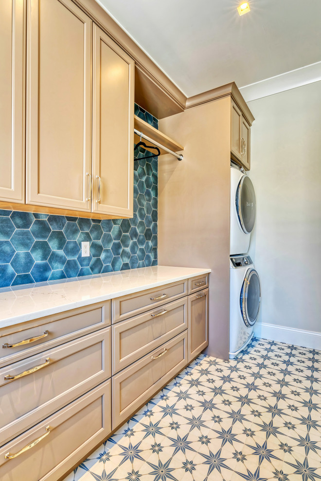 Photo of a mid-sized transitional galley dedicated laundry room in New York with light wood cabinets, blue splashback, porcelain splashback and a stacked washer and dryer.