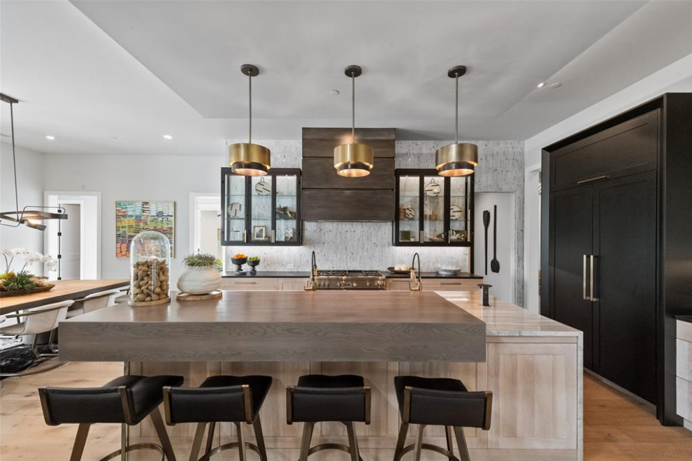 This is an example of a modern kitchen in Dallas with quartz worktops, ceramic splashback and light hardwood flooring.
