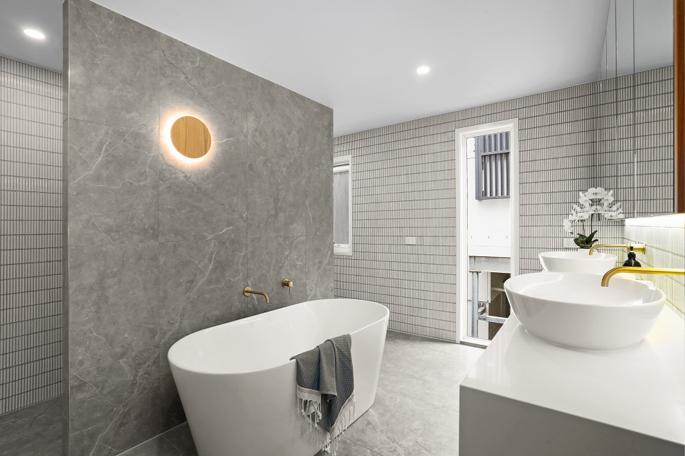 Photo of a mid-sized contemporary master bathroom in Brisbane with white cabinets, a freestanding tub, a curbless shower, gray tile, a vessel sink, grey floor, an open shower, white benchtops and a floating vanity.