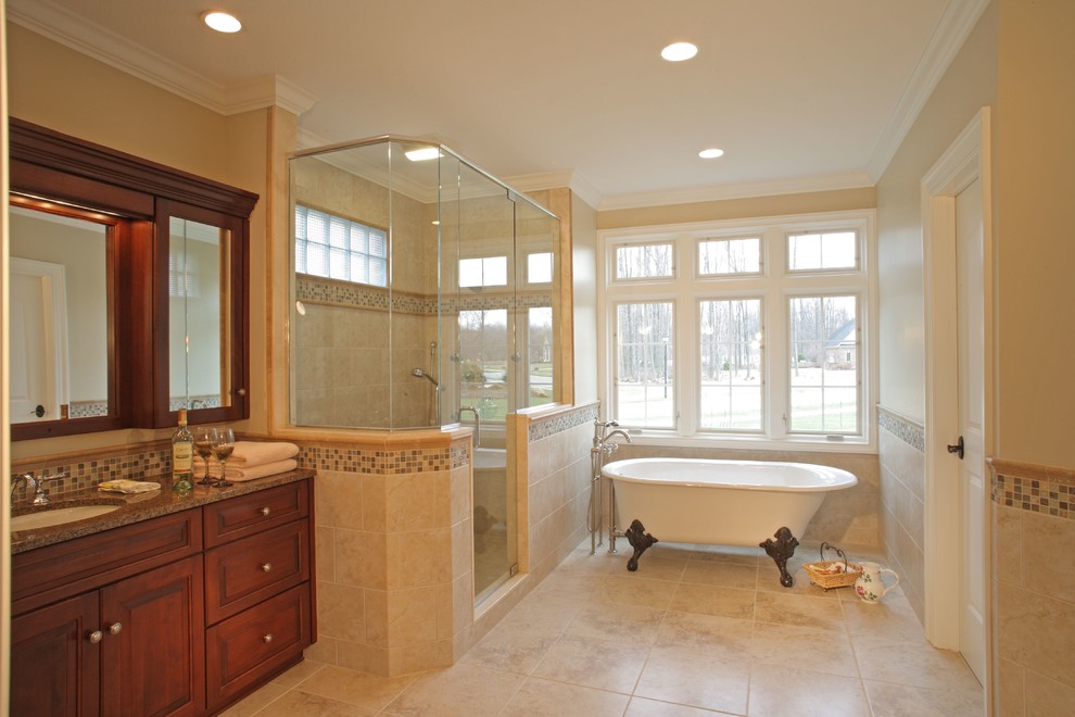 Photo of a large traditional master bathroom in Cleveland with an undermount sink, raised-panel cabinets, dark wood cabinets, granite benchtops, a claw-foot tub, a double shower, beige tile, mosaic tile, beige walls and travertine floors.