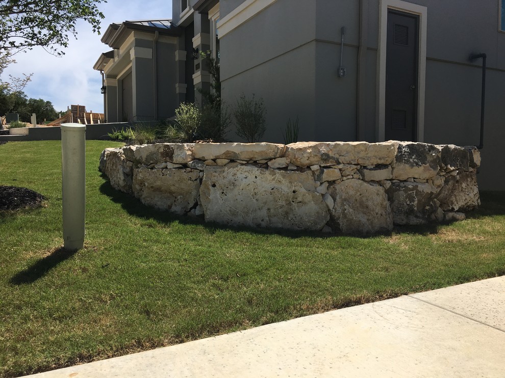 Inspiration for a small rustic stone retaining wall landscape.