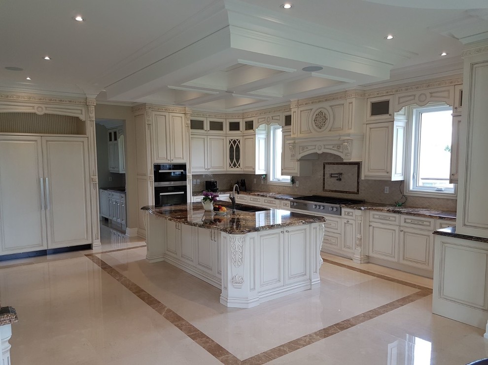 Photo of an expansive traditional l-shaped separate kitchen in Toronto with a double-bowl sink, raised-panel cabinets, white cabinets, granite benchtops, beige splashback, mosaic tile splashback, panelled appliances, porcelain floors, with island, beige floor and brown benchtop.