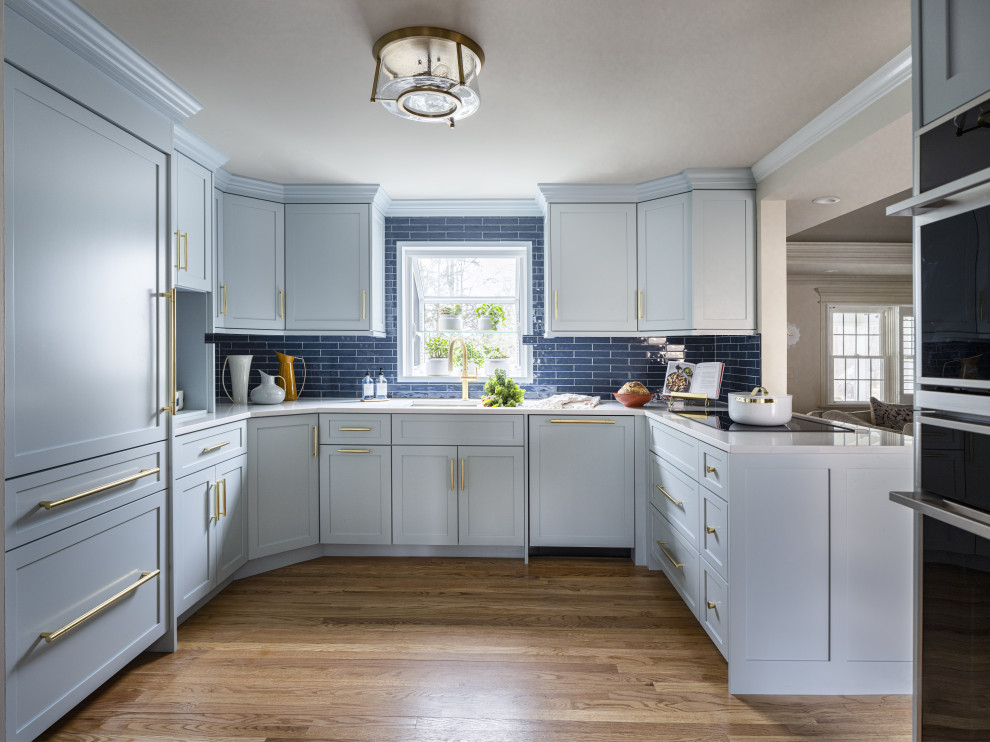 Inspiration for a small transitional u-shaped eat-in kitchen in Other with an undermount sink, shaker cabinets, blue cabinets, quartz benchtops, blue splashback, porcelain splashback, stainless steel appliances, light hardwood floors, no island and white benchtop.