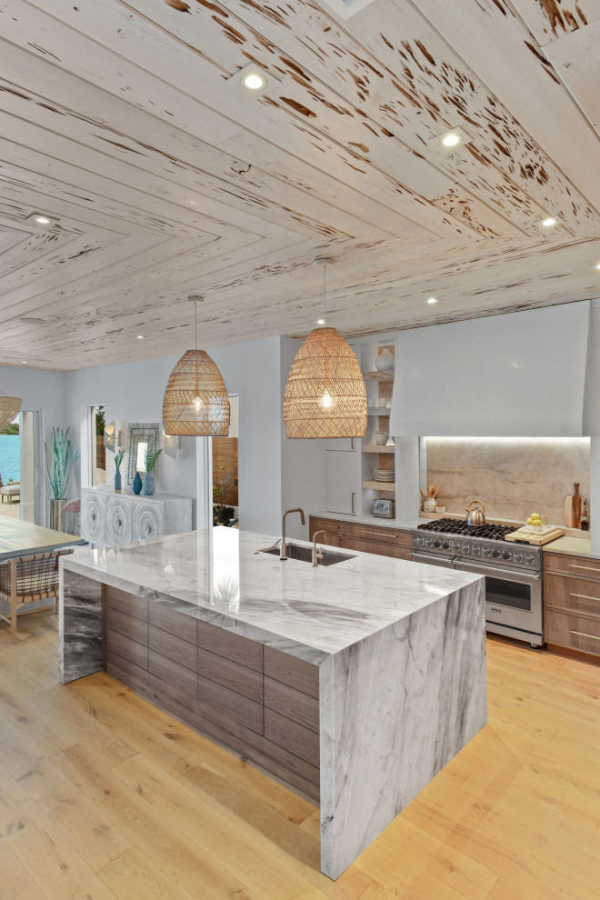 Mid-sized beach style l-shaped open concept kitchen photo in Other with distressed cabinets, quartzite countertops, paneled appliances and an island