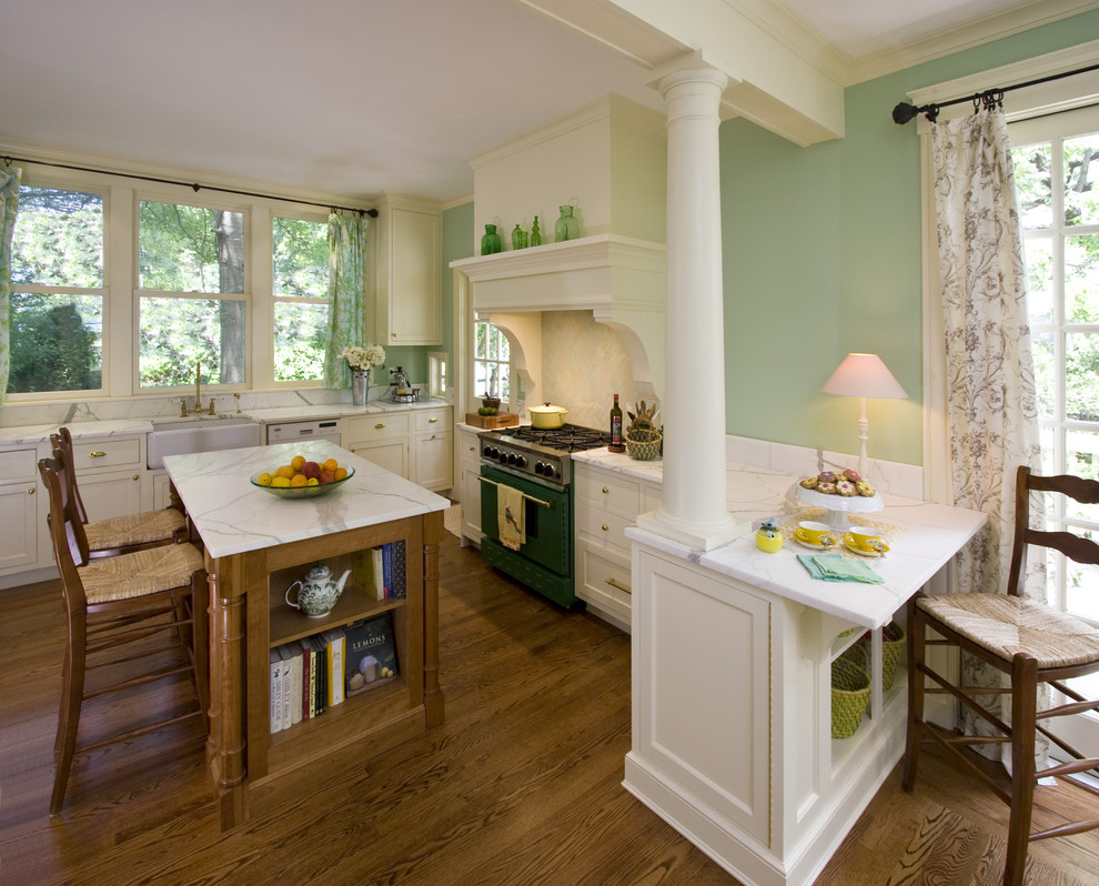 Large traditional u-shaped eat-in kitchen in New York with a farmhouse sink, beaded inset cabinets, white cabinets, marble benchtops, multi-coloured splashback, terra-cotta splashback, coloured appliances, medium hardwood floors and with island.