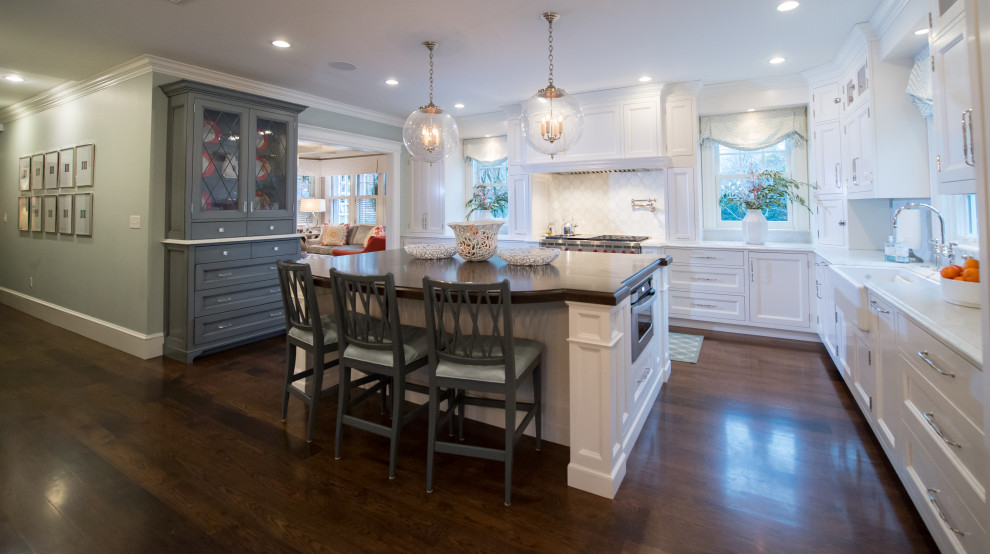 Inspiration for a large transitional l-shaped dark wood floor and brown floor eat-in kitchen remodel in Boston with a farmhouse sink, shaker cabinets, white cabinets, quartzite countertops, white backsplash, mosaic tile backsplash, paneled appliances, an island and white countertops