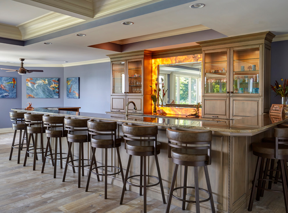 Photo of a large traditional u-shaped seated home bar in Chicago with raised-panel cabinets, medium wood cabinets, orange splashback, stone slab splashback, medium hardwood floors, brown floor, brown benchtop and granite benchtops.