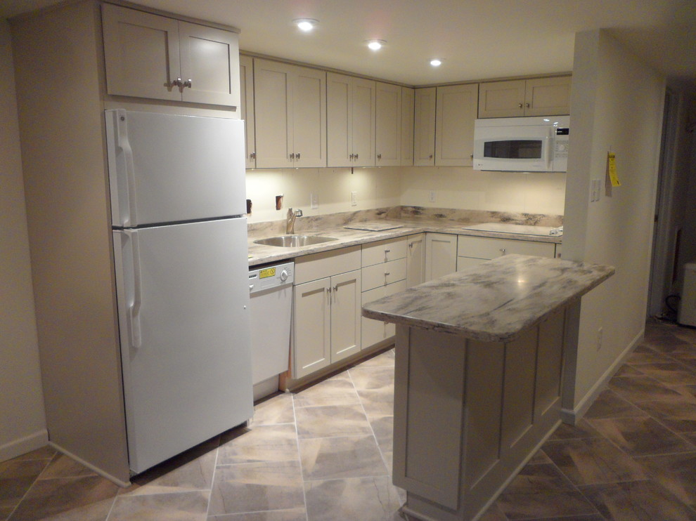 Photo of a transitional u-shaped eat-in kitchen in DC Metro with an undermount sink, shaker cabinets, beige cabinets, solid surface benchtops and white appliances.