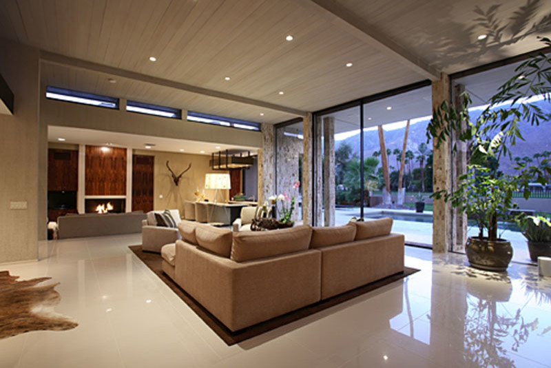 This is an example of a large contemporary open concept living room in Los Angeles with beige walls, ceramic floors, a standard fireplace and no tv.