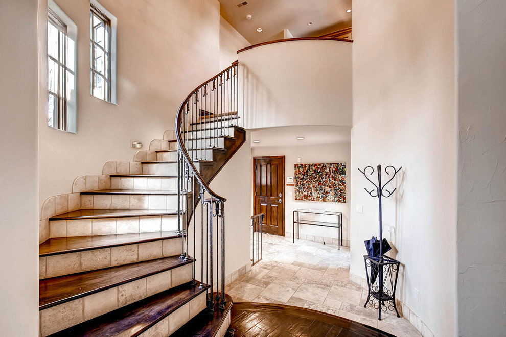 Design ideas for a mid-sized mediterranean wood curved staircase in Denver with tile risers.