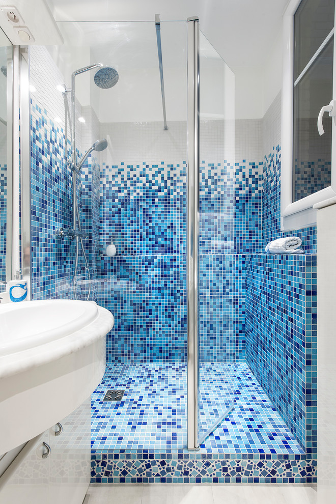 Small beach style master bathroom in Paris with a curbless shower, blue tile, mosaic tile, white walls, a trough sink, white floor, a hinged shower door, white benchtops and white cabinets.