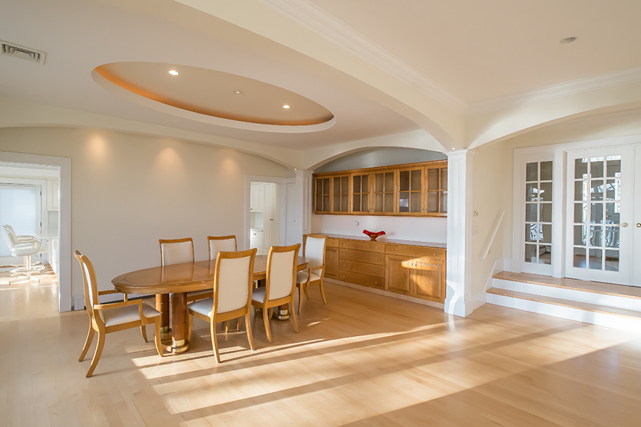 Dining room - large traditional light wood floor and beige floor dining room idea in Boston with white walls, a standard fireplace and a stone fireplace