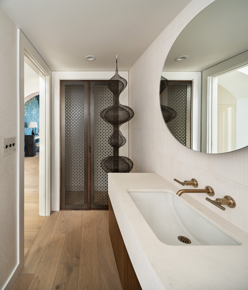 サンフランシスコにある高級な小さな北欧スタイルのおしゃれなトイレ・洗面所 (濃色木目調キャビネット、無垢フローリング、茶色い床、造り付け洗面台) の写真