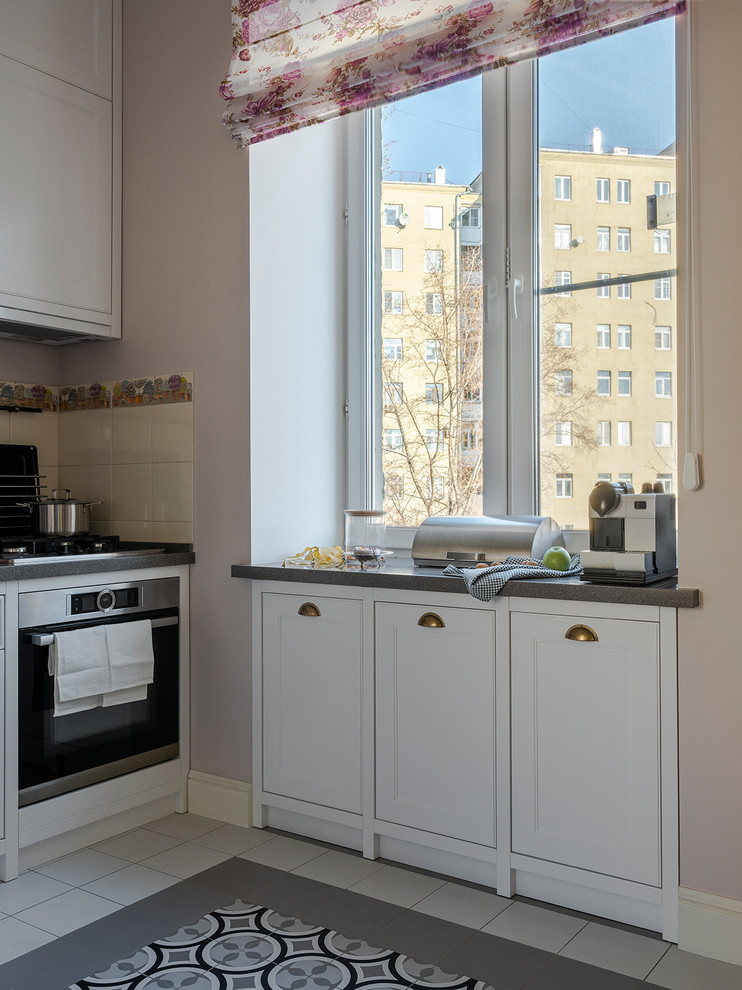 Design ideas for a small traditional single-wall eat-in kitchen in Moscow with an undermount sink, glass-front cabinets, white cabinets, quartz benchtops, beige splashback, ceramic splashback, stainless steel appliances, ceramic floors, grey floor and grey benchtop.