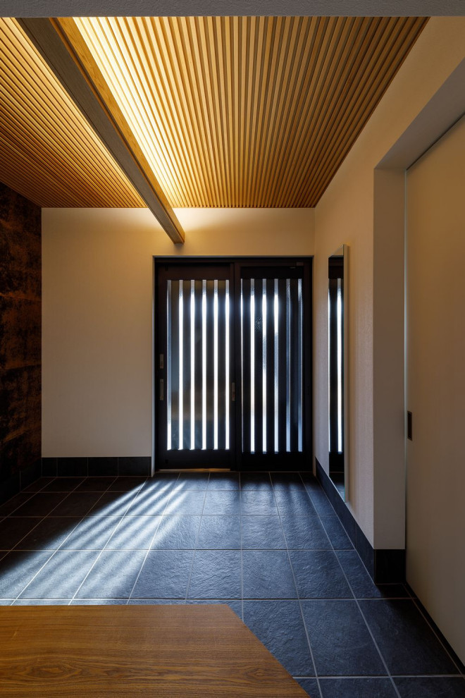 Свежая идея для дизайна: узкая прихожая среднего размера с белыми стенами, полом из керамической плитки, раздвижной входной дверью, черной входной дверью, черным полом, деревянным потолком и обоями на стенах - отличное фото интерьера