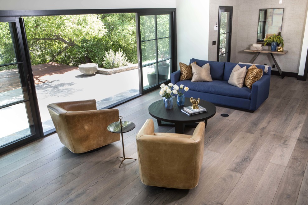 Photo of a large contemporary open concept living room in Los Angeles with white walls, medium hardwood floors and grey floor.