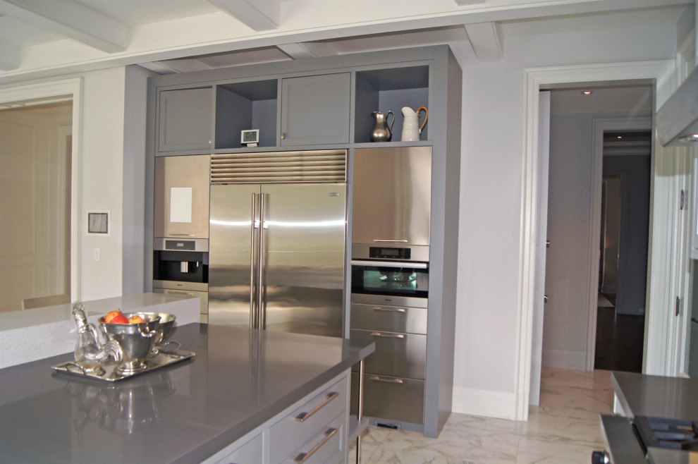 Inspiration for a large transitional l-shaped marble floor, gray floor and coffered ceiling enclosed kitchen remodel in Toronto with an integrated sink, flat-panel cabinets, stainless steel cabinets, quartz countertops, white backsplash, marble backsplash, stainless steel appliances, two islands and gray countertops