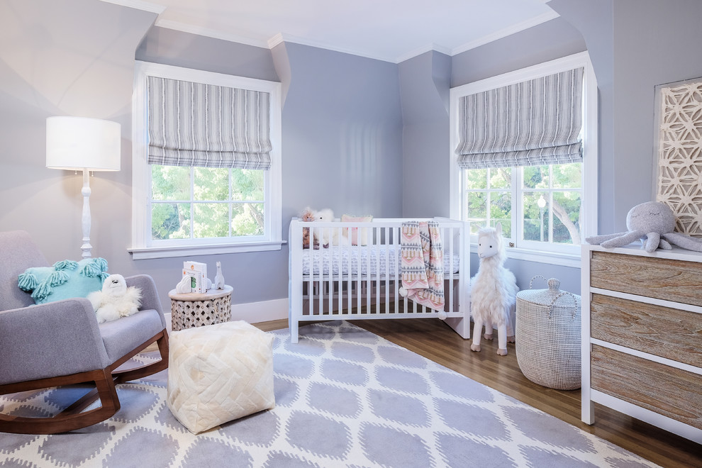 Design ideas for a large transitional nursery for girls in San Francisco with purple walls, medium hardwood floors and brown floor.