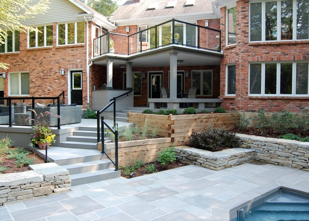 Large contemporary backyard full sun garden in Toronto with concrete pavers for summer.