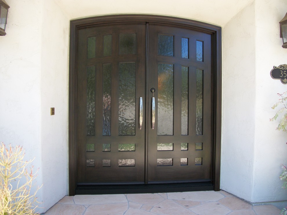 Mid-sized mediterranean front door in San Diego with white walls, travertine floors, a double front door, a dark wood front door and beige floor.