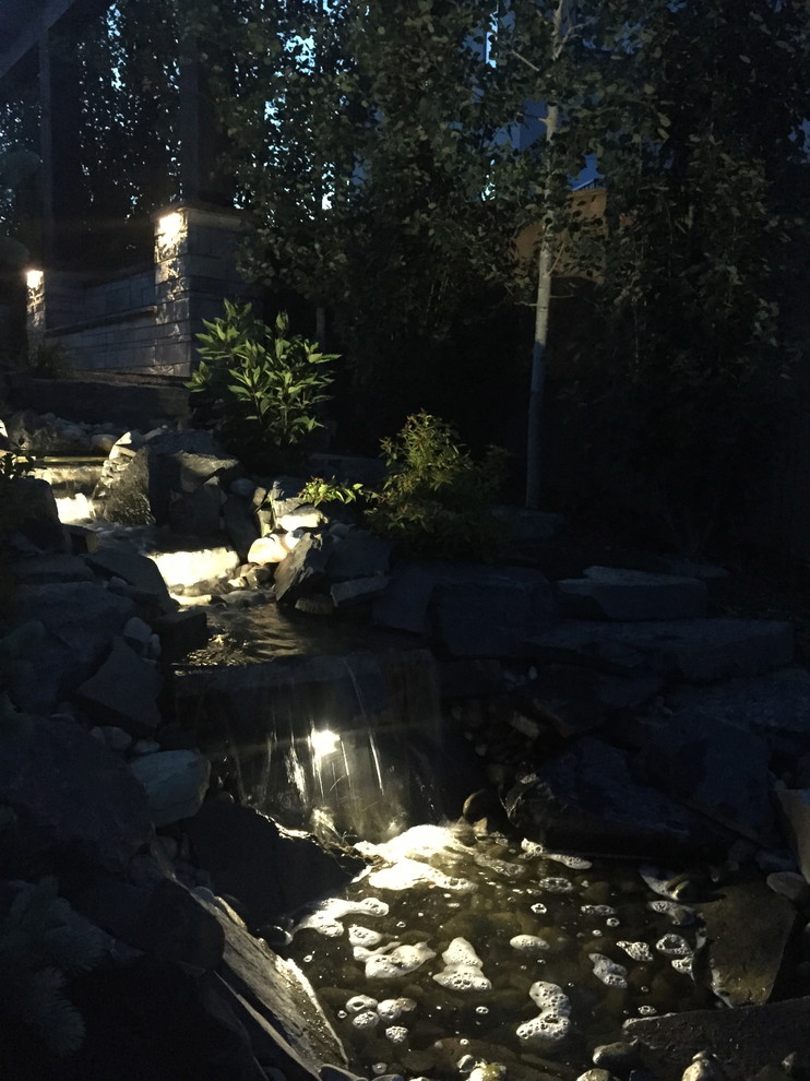 Design ideas for a mid-sized rustic front yard concrete paver garden path in Calgary.