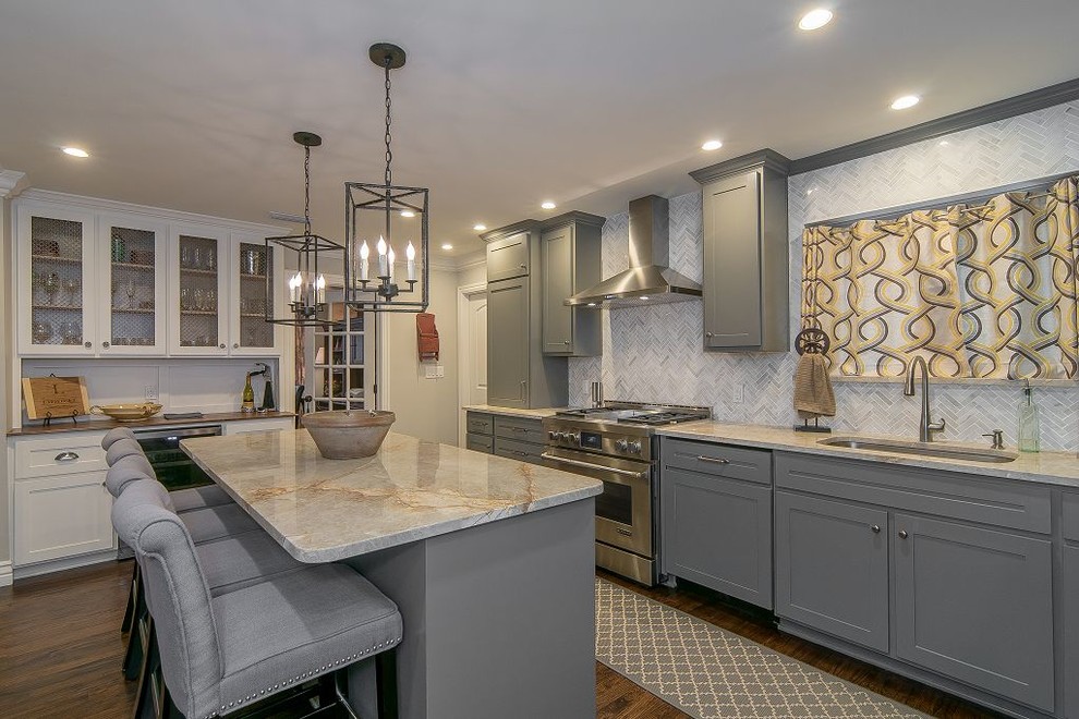 Photo of a large transitional l-shaped open plan kitchen in Dallas with an undermount sink, white splashback, stainless steel appliances, dark hardwood floors, with island and grey cabinets.