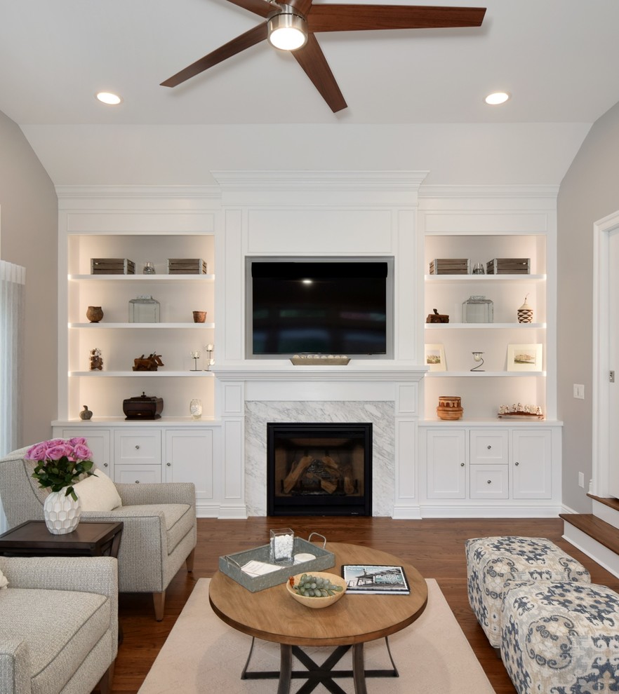 Design ideas for a mid-sized transitional open concept family room in New York with grey walls, medium hardwood floors, a standard fireplace, a tile fireplace surround, a wall-mounted tv and brown floor.