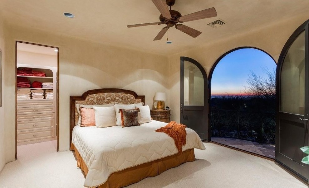 This is an example of an expansive mediterranean guest bedroom in Dallas with beige walls, carpet, no fireplace, beige floor and a brick fireplace surround.