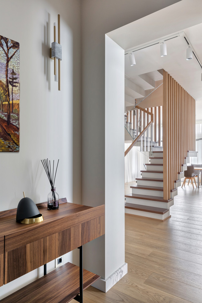 Стильный дизайн: большая п-образная бетонная лестница в современном стиле с деревянными ступенями и деревянными перилами - последний тренд