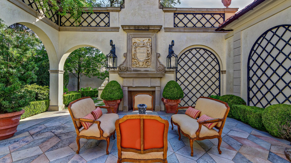 Photo of a traditional courtyard patio in Dallas with with fireplace and no cover.