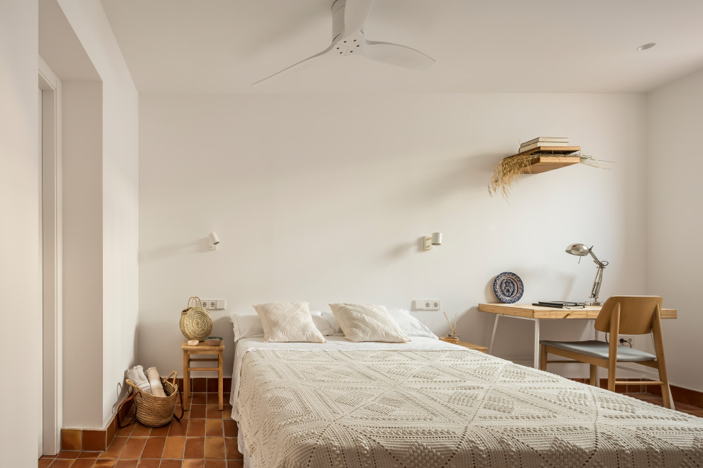 Idées déco pour une petite chambre méditerranéenne avec un mur blanc, tomettes au sol et un sol marron.