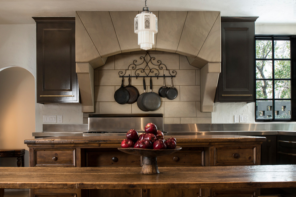 Example of a large mountain style u-shaped kitchen design with dark wood cabinets, stainless steel appliances and an island