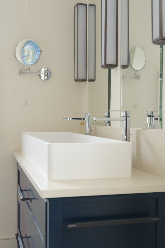 Design ideas for a mid-sized eclectic master bathroom in Sussex with furniture-like cabinets, blue cabinets, a drop-in tub, a curbless shower, a two-piece toilet, beige walls, cement tiles, a trough sink, limestone benchtops, blue floor, a hinged shower door and beige benchtops.