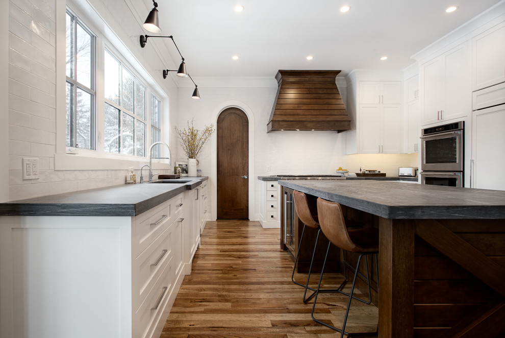 Eat-in kitchen - large transitional u-shaped eat-in kitchen idea in Calgary with shaker cabinets, paneled appliances and an island