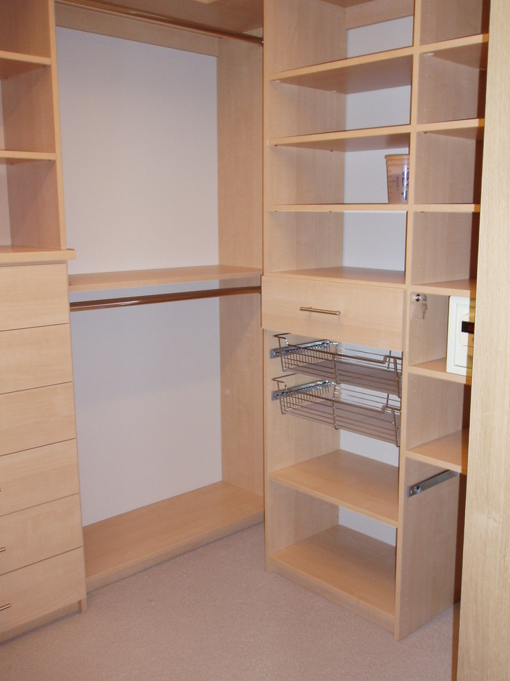 Photo of a mid-sized transitional gender-neutral walk-in wardrobe in Denver with open cabinets, medium wood cabinets, carpet and beige floor.