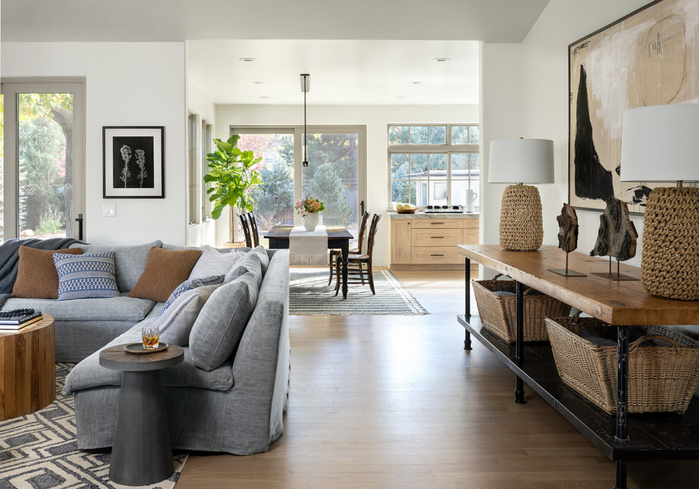 Mid-sized farmhouse open concept light wood floor, brown floor and vaulted ceiling living room photo in Denver with a standard fireplace and a stacked stone fireplace