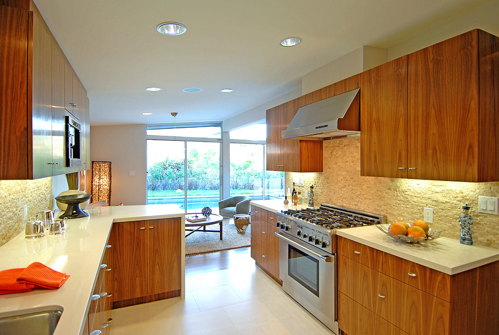 Photo of a midcentury l-shaped open plan kitchen in Los Angeles with an undermount sink, flat-panel cabinets, medium wood cabinets, quartz benchtops, beige splashback and stainless steel appliances.