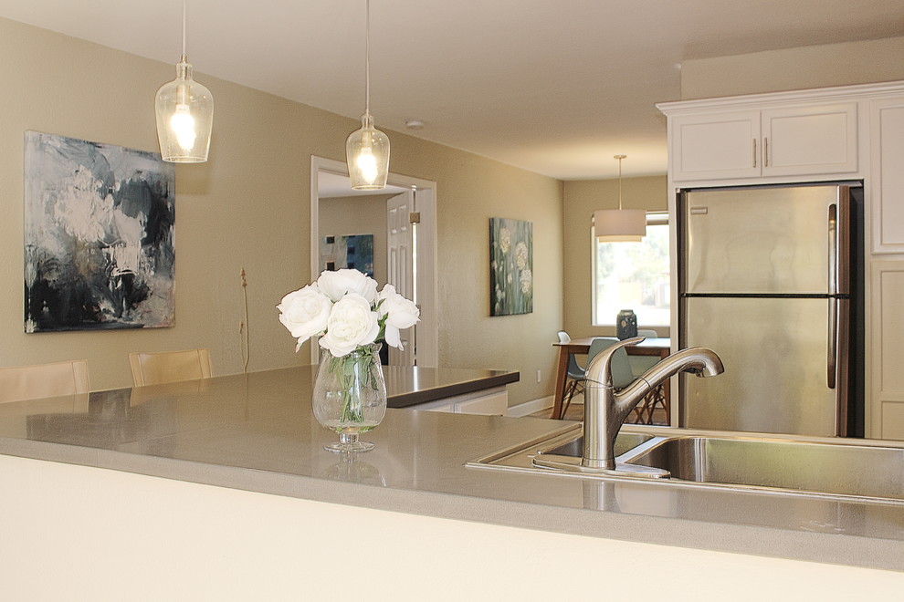 Inspiration for a small transitional l-shaped terra-cotta tile eat-in kitchen remodel in Phoenix with a drop-in sink, shaker cabinets, white cabinets, quartzite countertops, white backsplash, mosaic tile backsplash, stainless steel appliances and a peninsula
