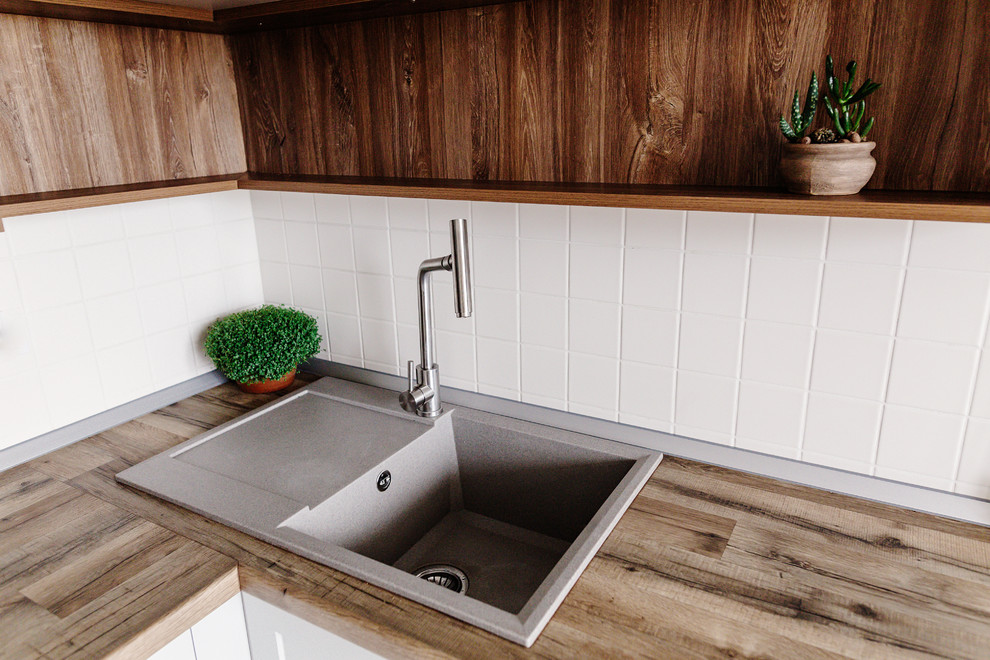 Example of a mid-sized transitional u-shaped dark wood floor and brown floor eat-in kitchen design in DC Metro with a drop-in sink, recessed-panel cabinets, white cabinets, wood countertops, white backsplash, ceramic backsplash, stainless steel appliances, a peninsula and brown countertops