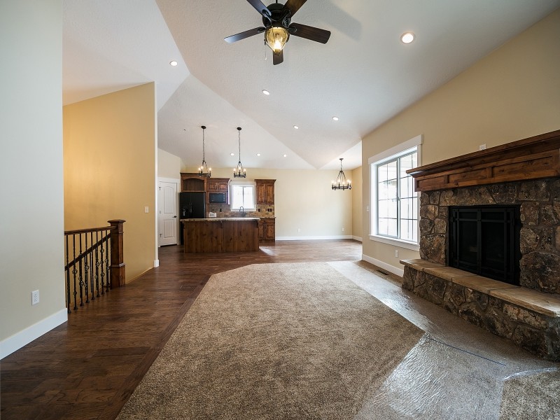 Photo of a large arts and crafts open concept family room in Salt Lake City with beige walls, carpet, a standard fireplace and a stone fireplace surround.