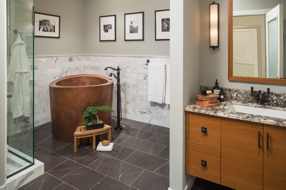 Photo of a large traditional master bathroom in Minneapolis with flat-panel cabinets, light wood cabinets, a japanese tub, an open shower, black and white tile, stone slab, grey walls, marble floors, marble benchtops, a one-piece toilet and an integrated sink.