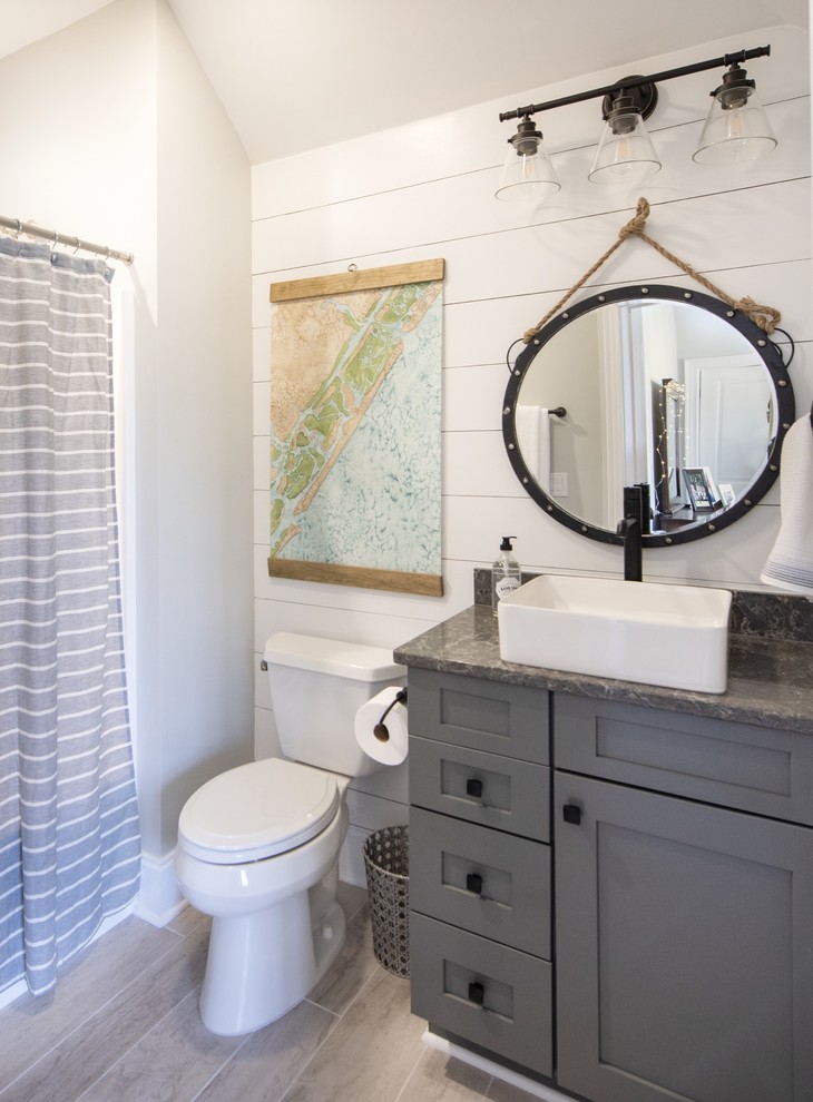 Inspiration for a beach style bathroom in Other with shaker cabinets, grey cabinets, a two-piece toilet, white walls, a vessel sink, beige floor and grey benchtops.