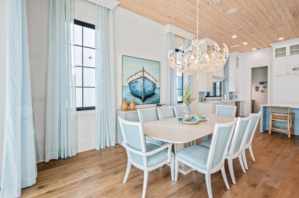 Foto di una sala da pranzo aperta verso la cucina costiera con pareti bianche, pavimento in legno massello medio, pavimento marrone e soffitto in legno